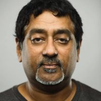 istockphoto-1069992630-612×612 Close up portrait of indian mature man with blank expression against gray background. Vertical shot of real malaysian man staring in studio with black hair. Photography from a DSLR camera. Sharp focus on eyes.